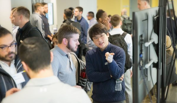 Students discuss a poster in a crowded hallway