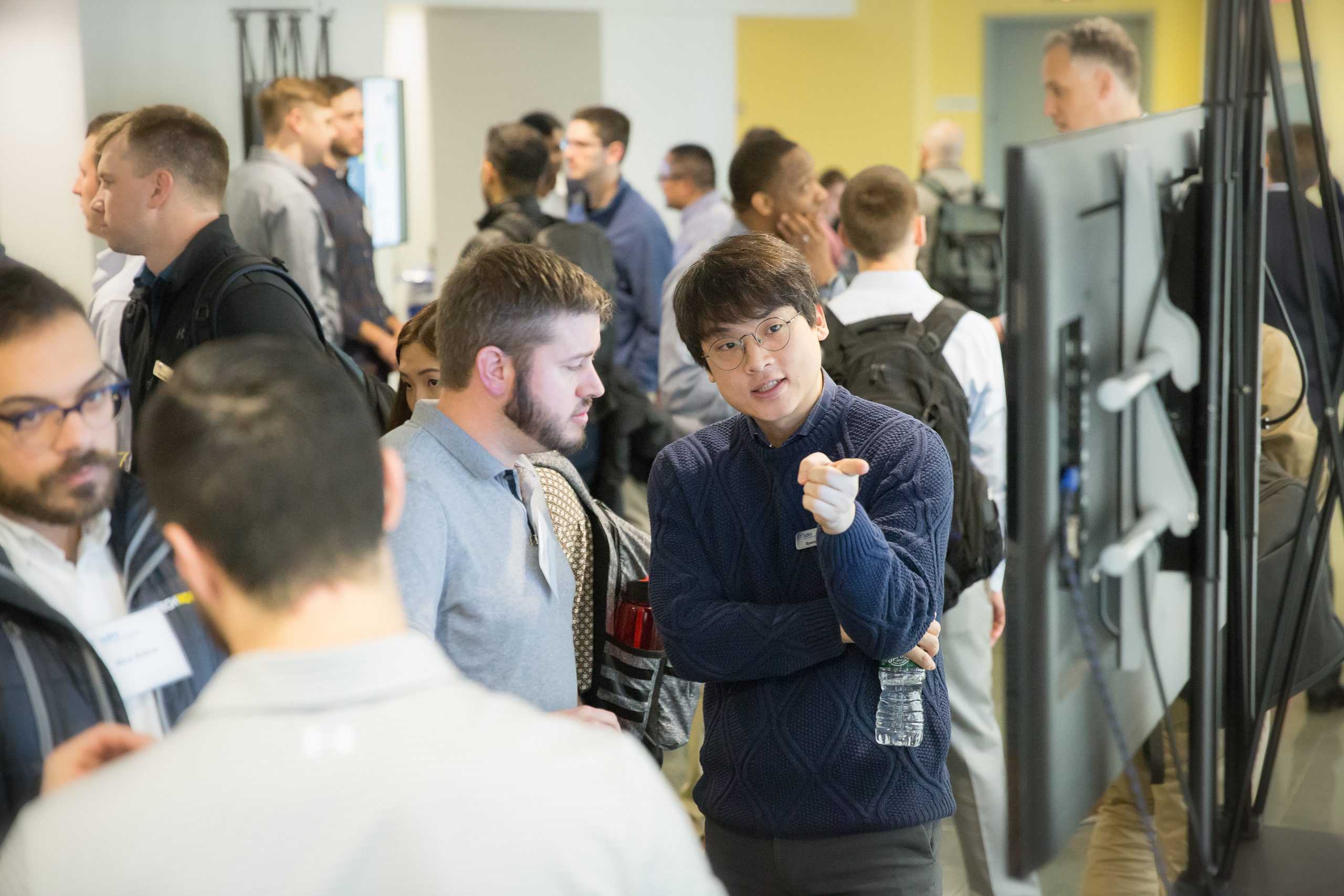 Students discuss a poster in a crowded hallway