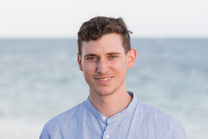 Portrait of Daniel Anastos standing in front of the ocean